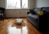 Salon domu jednorodzinnego w trakcie mycia podłogi, wiadro i mop
