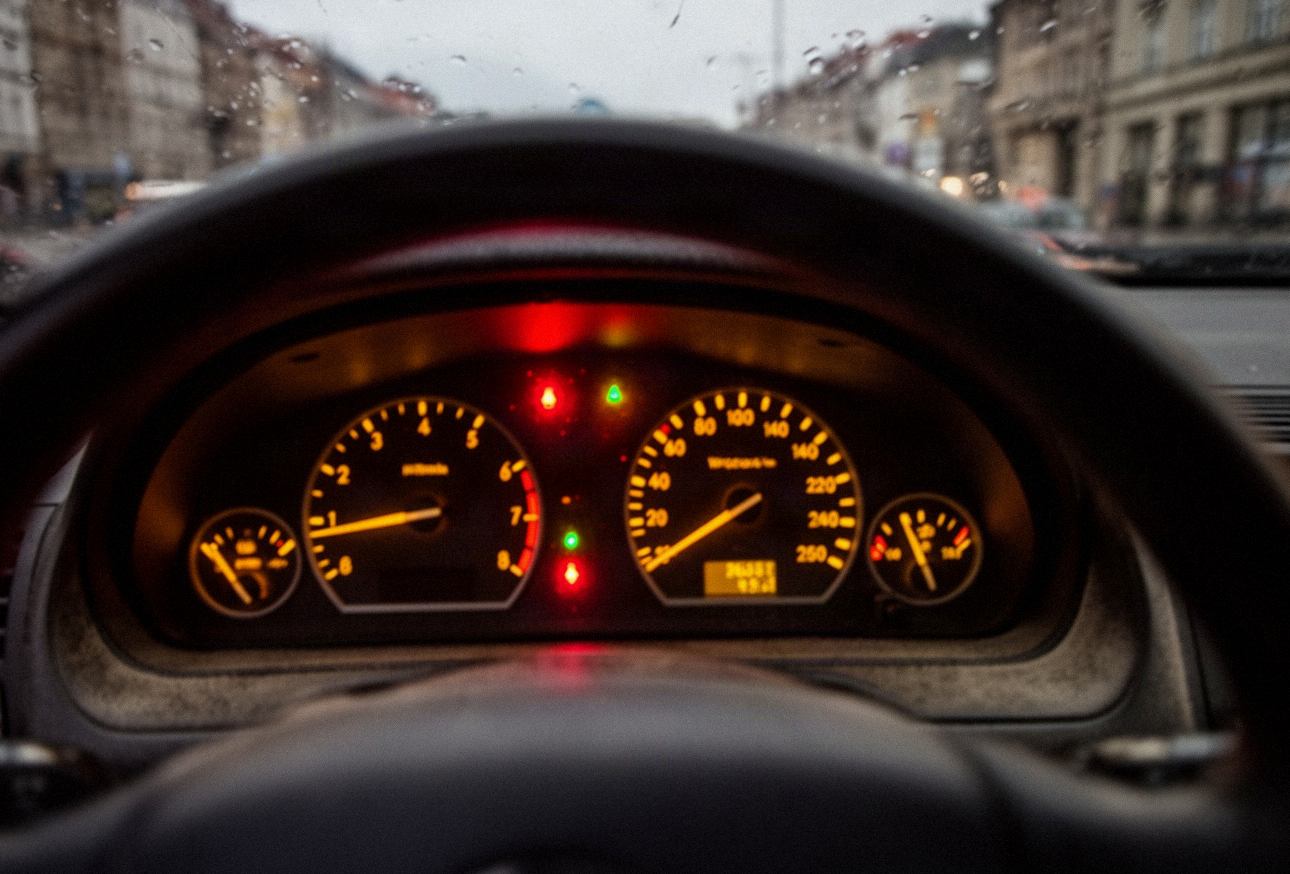 Podświetlone zegary i kontrolki na desce rozdzielczej samochodu o zmierzchu