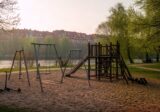 Pusty plac zabaw w miejskim parku nad rzeką we Wrocławiu